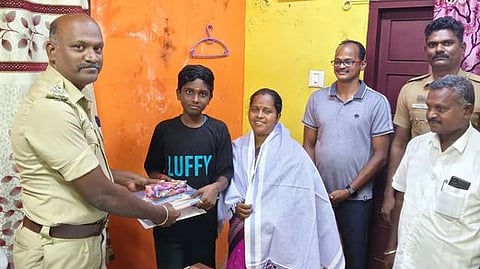  அரிமளத்தில் சனிக்கிழமை சிறுவன் கதிரவன், அவரது தாய் அஞ்சலிதேவி ஆகியோரைப் பாராட்டிய காவல் உதவி ஆய்வாளா் குருநாதன். 