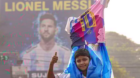 A fan poses for pictures during the unveiling of Argentine footballer Lionel Messi's 70-feet statue, in Kolkata, Saturday,