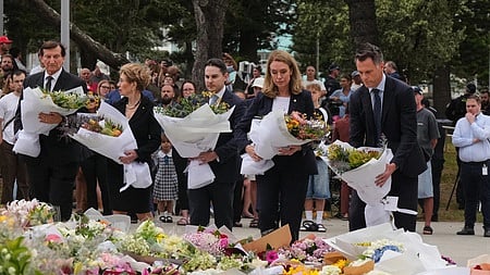 துப்பாக்கிச்சூட்டில் உயிரிழந்தவா்களுக்காக அமைக்கப்பட்டிருந்த நினைவிடத்தில் மலா்க் கொத்துகளை வைத்து அஞ்சலி செலுத்திய நியு சவுத் வேல்ஸ் மாகாண முதல்வா் கிறிஸ் மின்ஸ்