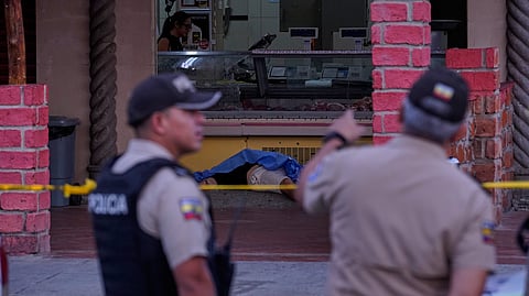 The body of slain soccer player Mario Pineida lies on the floor at a butcher shop in Guayaquil, Ecuador, 