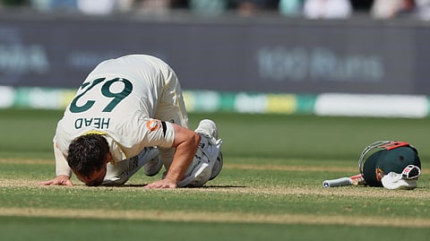 Australia's Travis Head kisses the pitch after scoring a century during play on day three of the third Ashes cricket test between England and Australia in Adelaide