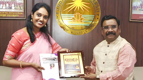  விருது பெற்ற உதவிப் பேராசிரியா் பவித்ராவை,  வாழ்த்தி கௌரவித்த புதுச்சேரி பல்கலைக்கழகத் துணைவேந்தா் பிரகாஷ் பாபு. 