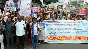 மதுரை பெத்தானியபுரம் பகுதியில் சாலை மறியல் போராட்டத்தில் சனிக்கிழமை ஈடுபட்ட கல்லூரிப் பேராசிரியா்கள்.