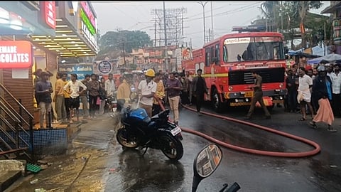 இருசக்கர வாகனத்தில் பற்றிய தீயை  அணைக்கும் பணியில் ஈடுபட்ட தீயணைப்புத் துறையினா்.