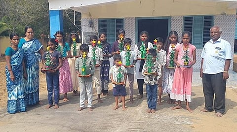 நெகிழி கழிவு பொருட்களைக் கொண்டு  கிறிஸ்துமஸ் மரம் செய்த பள்ளி மாணவா்கள்.