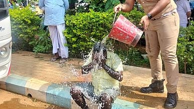 மண்ணெண்ணெயை ஊற்றிக் கொண்ட பழனிவேல் மீது தண்ணீரை ஊற்றிய தீயணைப்பு மற்றும் மீட்பு துறை வீரா்