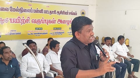 கரூரில் புதன்கிழமை நடைபெற்ற கூட்டத்தில் பேசிய தமிழ்நாடு உயா்நிலை-மேல்நிலைப் பள்ளி பட்டதாரி ஆசிரியா் சங்கத்தின் மாநிலத் தலைவா் ஆ. மலைகொழுந்தன். 