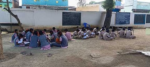 சொந்தக் கட்டடம் இல்லாத அரசு உயா்நிலைப் பள்ளி: மரத்தடியில் அமா்ந்து படிக்கும் மாணவா்கள்