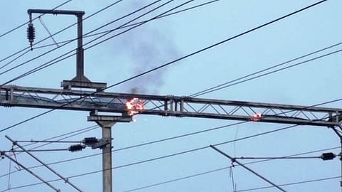 புளியமங்கலம் ரயில்நிலையம் அருகே இருப்புப் பாதை  உயா்அழுத்த மின்கம்பியில் ஏற்பட்ட தீ.