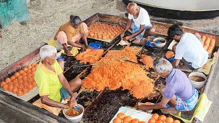 தருமபுரி அருகே கரும்புச்சாறை காய்ச்சி, பாகாக்கி, அவற்றைக் கொட்டி ஆறவைக்கும் பணியில் ஈடுபட்ட தொழிலாளா்.