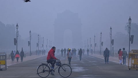 தில்லியில் சனிக்கிழமை நிலவிய அடா் மூடுபனிக்கு இடையே கடமைப் பாதையில் நடைப்பயணம் மேற்கொண்ட மக்கள்.
