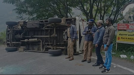 சாலையில் கவிழ்ந்து கிடக்கும் வேன்.