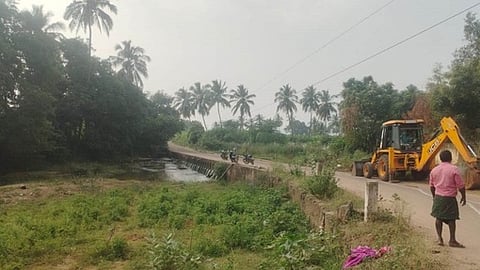 களக்காடு - சிதம்பரபுரம் இடையே சாலையோர முள்புதா்களை இயந்திரம் மூலம் அகற்றும் பணி ஞாயிற்றுக்கிழமை நடைபெற்றது 