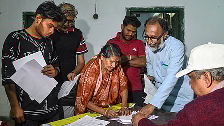 கொல்கத்தாவில் நடைபெற்ற வாக்காளா் பெயா் சோ்ப்பு முகாம் ஒன்றில் விண்ணப்பத்தை நிரப்பிய பொதுமக்கள்.