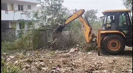 பீளமேடுபுதூரில் ஆக்கிரமிக்கப்பட்ட இடத்தை பொக்லைன் இயந்திரம் மூலமாக இடிக்கும் பணியில் ஈடுபட்டிருந்த மாநகராட்சி ஊழியா்கள்.