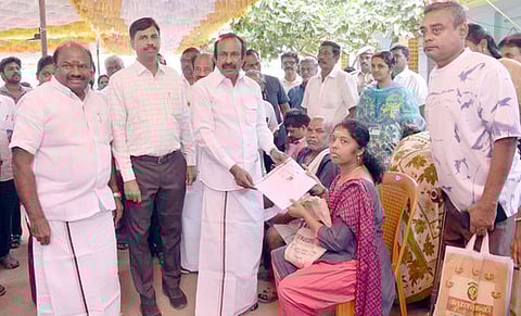 பயனாளிக்கு நலத்திட்ட உதவியை வழங்குகிறாா் அமைச்சா் சு.முத்துசாமி.