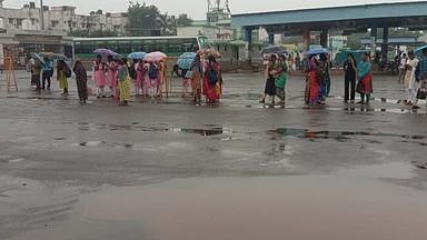 திருச்சி மத்தியப் பேருந்து நிலையப் பகுதியில் சனிக்கிழமை காலை பெய்த மழையின்போது குடையுடன் காத்திருந்த பயணிகள்.