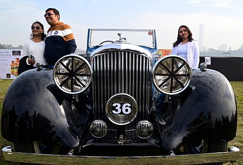 கொல்கத்தாவில் நடைபெற்ற 55வது ஸ்டேட்ஸ்மேன் விண்டேஜ் மற்றும் கிளாசிக் கார் பேரணியின் போது, ​​பாரம்பரிய விண்டேஜ் மோரிஸ் கேரேஜ் கார் அருகில் நின்று புகைப்படம் எடுத்து கொண்ட பார்வையாளர்கள்.