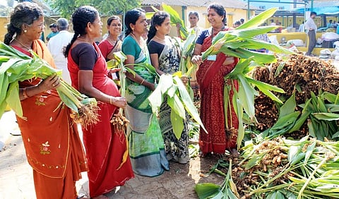 தருமபுரி உழவா் சந்தையில் மஞ்சள் கொத்துகளை வாங்கிய பெண்கள்.