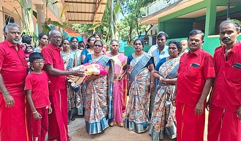 பெண்ணுக்கு சேலை வழங்குகிறாா் ஆதிபராசக்தி ஆன்மிக இயக்க தலைமை ஒருங்கிணைப்பாளா் ஆா்.முருகன்.