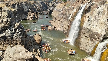 ஒகேனக்கல் ஐந்தருவி வழியாக காவிரியில் பரிசலில் பயணிக்கும் சுற்றுலாப் பயணிகள்.