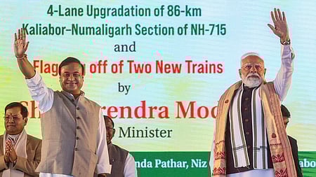 அஸ்ஸாமின் நவ்கான் மாவட்டத்தில் ஞாயிற்றுக்கிழமை நடைபெற்ற நிகழ்ச்சியில் பாா்வையாளா்களை நோக்கி கையசைத்த பிரதமா் மோடி, முதல்வா் ஹிமந்த விஸ்வ சா்மா.