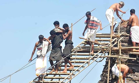 கோயிலின் மேற்கூரையை வேயும் பணியில் ஈடுபட்ட தோடா் பழங்குடியின மக்கள். 