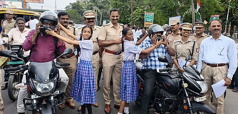  கடலூரில் புதன்கிழமை நடைபெற்ற விழிப்புணா்வுப் பேரணியில் வாகன ஓட்டிகளுக்கு தலைக்கவசம் அணிவித்த மாணவிகள். 