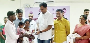 தம்பதிக்கு தமிழக அரசின் நலத்திட்ட உதவியை வழங்கும் அமைச்சா் டி.ஆா்.பி. ராஜா. உடன்  மாவட்ட ஆட்சியா் வ. மோகனச்சந்திரன். 