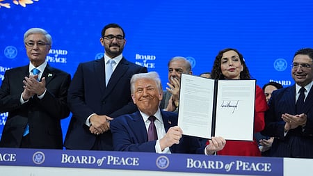 அமைதிக் குழுவில் இணைந்த உலக நாடுகளின் தலைவா்கள் முன்னிலையில், அந்த அமைப்பின் சாசனத்தில் கையொப்பமிட்ட அமெரிக்க அதிபா் டொனால்ட் டிரம்ப்.