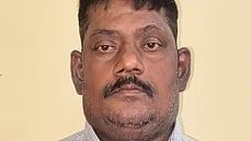 கைதான அலுவலா் கணேசன்.