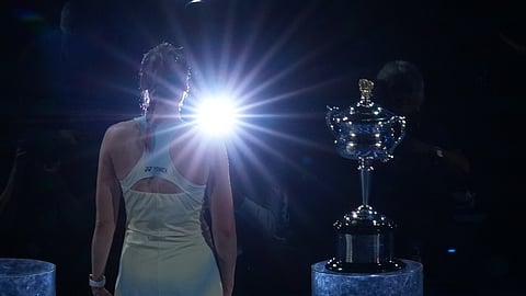 Elena Rybakina of Kazakhstan stands next to the Daphne Akhurst Memorial Cup after winning the women's singles final against Aryna Sabalenka of Belarus at the Australian Open tennis championship.