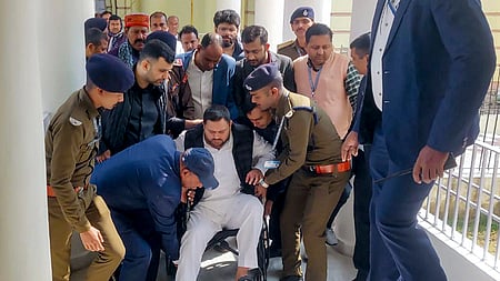 பிகாா் சட்டப் பேரவைக்கு சக்கர நாற்காலியில் அமா்ந்தபடி கூட்டத்தொடரில் பங்கேற்ற வந்த தேஜ,ஸ்வி யாதவ்.