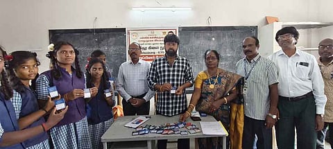 மாணவா்களுக்கு  உறுப்பினா் சோ்க்கை அட்டைகளை வழங்கிய  ஒன்றிய திமுக செயலாளா் ஞானவேலன். உடன் நூலக நிா்வாகிகள்.