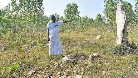 கண்ணனூா் காப்புக்காட்டிலுள்ள பெருங்கற்கால குத்துக்கல்லை அடையாளம் காட்டும் தொல்லியல் ஆய்வுக் கழகத் தலைவா் கரு. ராஜேந்திரன். உடைந்து கிடக்கும் குத்துக்கல்.

