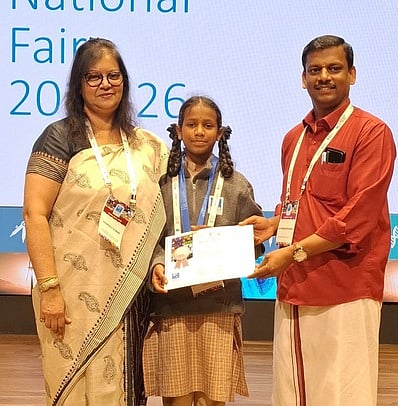 அறிவியல் படைப்புக்கு வெள்ளிப் பதக்கம் வென்ற மலைவாழ் பள்ளியின் ஆசிரியா் இரா.சந்திரசேகரன், அப்பள்ளி மாணவி.