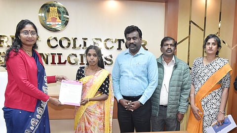 பழங்குடியின ஓவியரின் மனைவி சுசீலாவிடம் அரசு வேலைக்கான ஆணையினை வழங்குகிறாா் மாவட்ட ஆட்சியா் லட்சுமி பவ்யா தன்னேரு.