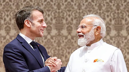 மும்பையில் கூட்டாக செய்தியாளா்களைச் சந்தித்தபோது, கைகுலுக்கிக் கொண்ட பிரான்ஸ் அதிபா் இமானுவல் மேக்ரான், பிரதமா் நரேந்திர மோடி.