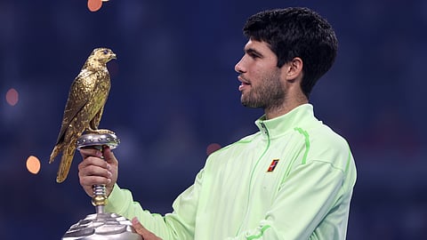 Spain's Carlos Alcaraz holds the trophy after beating Arthur Fils of France during the final of Qatar Open tennis in Doha, Qatar, Saturday Feb. 21, 2026. (AP Photo/Hussein Sayyed)