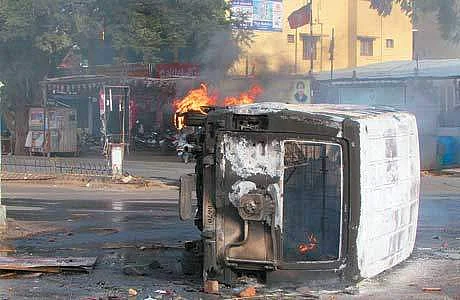 துடியலூர் சந்திப்புப் பகுதியில் கொளுத்தப்பட்ட காவல் துறை ஜீப்.