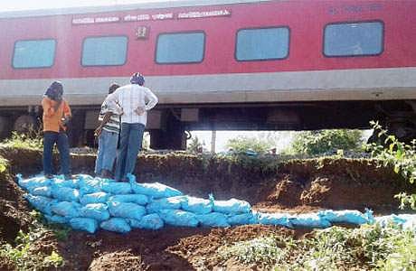 மின்னூர் பகுதியில் ரயில்வே இருப்புப் பாதையோரம் மண் சரிவு ஏற்பட்ட இடத்தை சரி செய்யும் பணியில் ஈடுபட்ட ரயில்வே பணியாளர்கள்.