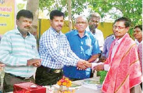 கணினிகள் வாங்கித் தந்த ஆசிரியரைப் பாராட்டும் மாவட்ட முதன்மைக் கல்வி அலுவலர் மு. ராமசாமி.