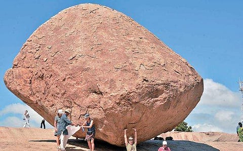 மாமல்லபுரம்  வெண்ணை  உருண்டைப்  பாறையைத்  தாங்குவது போல் படம்  எடுத்துக் கொள்ளும்  வெளிநாட்டு சுற்றுலாப்  பயணி. 