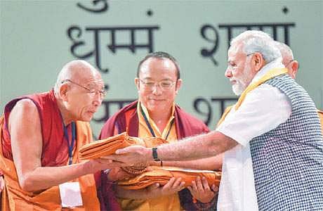 தில்லியில் திங்கள்கிழமை நடைபெற்ற நிகழ்ச்சியில்,  புத்த மதத் துறவிக்கு பரிசுகள் வழங்கி கெளரவிக்கும் பிரதமர் மோடி.