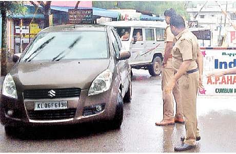 தேனி மாவட்டம், கம்பம்மெட்டில் சோதனைச் சாவடிக்கு உரிய வசதிகள் இல்லாததால், மழையில் நனைந்தவாறே வியாழக்கிழமை வாகனச் சோதனையில் ஈடுபட்ட தமிழக போலீஸார்.