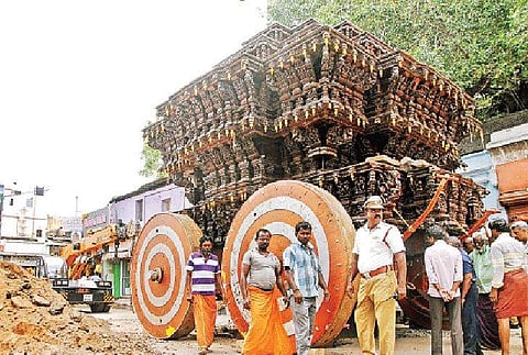 மதுரை மீனாட்சியம்மன் கோயில் தேருக்கு செவ்வாய்க்கிழமை சக்கரம் பொருத்தும் பணியில் ஈடுபட்ட தொழிலாளர்கள்.