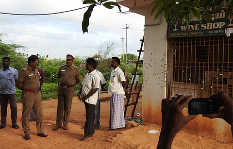 திருட்டு நடைபெற்ற மதுக்கடை அருகே விசாரணையில் ஈடுபட்ட போலீஸாா்.