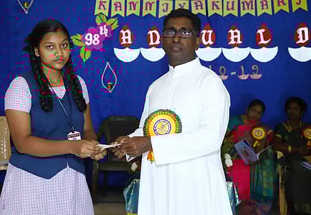 மாணவிக்கு பரிசு வழங்குகிறாா் பள்ளித் தாளாளா் ஜோசப் ரொமால்டு.