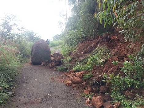 பண்ணைக்காடு பகுதியில் இருந்து கூடம் நகா் கிராமத்திற்கு செல்லும் சாலையில் உருண்டு விழுந்த பாறை.