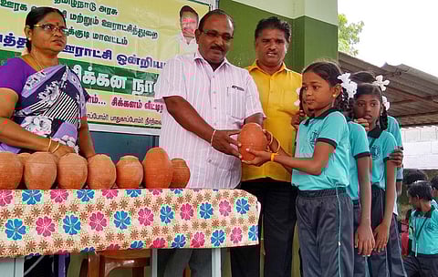 சேமிப்புப் பழக்கத்தை ஏற்படுத்தும் வகையில் பள்ளி மாணவா்களுக்கு உண்டியல் வழங்குகிறாா் கயத்தாறு ஊராட்சி ஒன்றிய ஆணையா் முத்துகுமாா்.